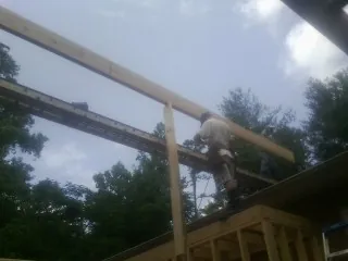 Carpenter setting a ridge beam over a new addition frame — Ice Dam Removal by Roofing Brothers in Plattsmouth