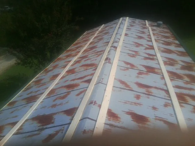 Rusted metal roof panels with new wood purlins before replacement — Storm Damage Roof Repair in Plattsmouth by Roofing Brothers