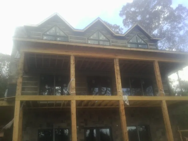 Dormers and porch framing on a large log home under construction — Roof Coating work by our crew in Plattsmouth
