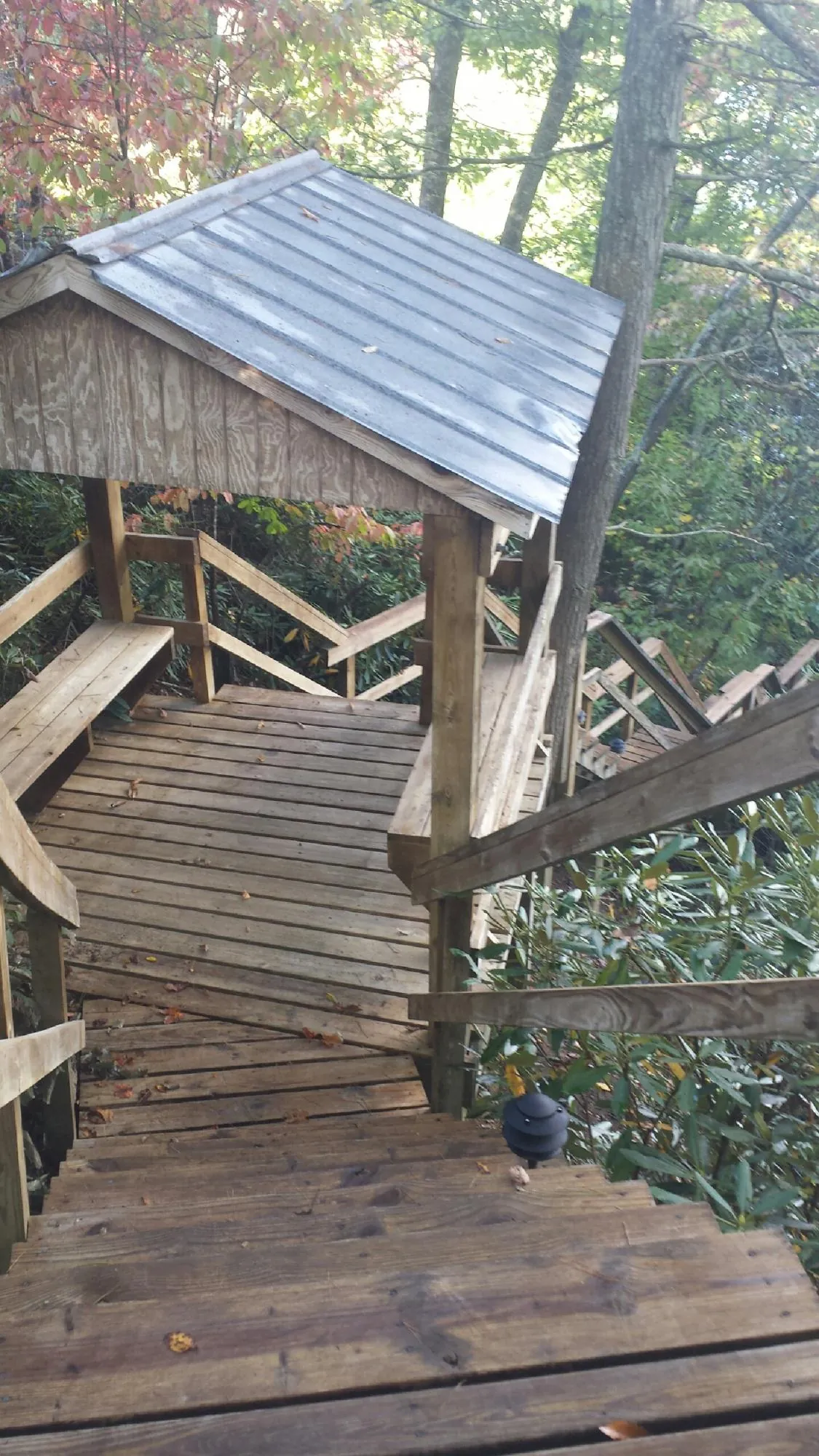 Metal roofed shelter over wooden steps on a wooded walkway — Skylight Repair & Installation work by our crew in Plattsmouth
