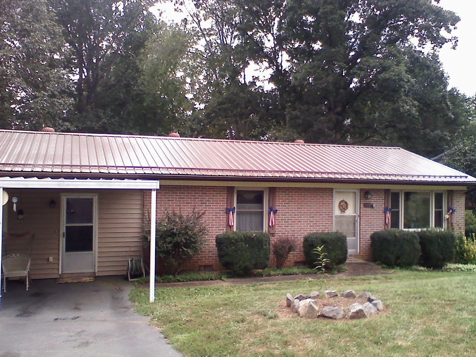 Bronze metal roof and carport on a brick ranch home — Roof Repair work by our crew in Plattsmouth